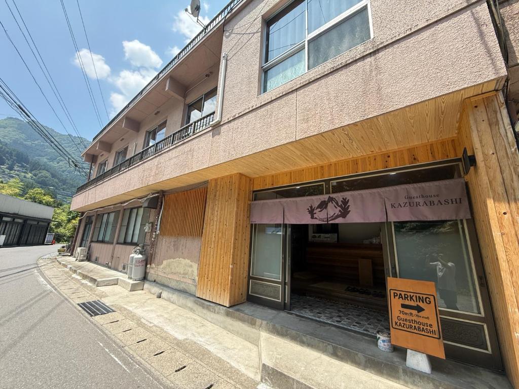a building with a sign on the side of it at Guesthouse KAZURABASHI in Miyoshi
