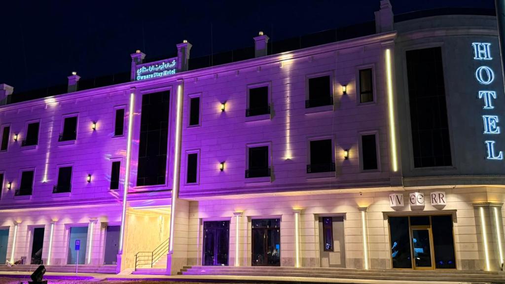 a white building with a neon sign on it at فندق أونارا ستاي in Medina