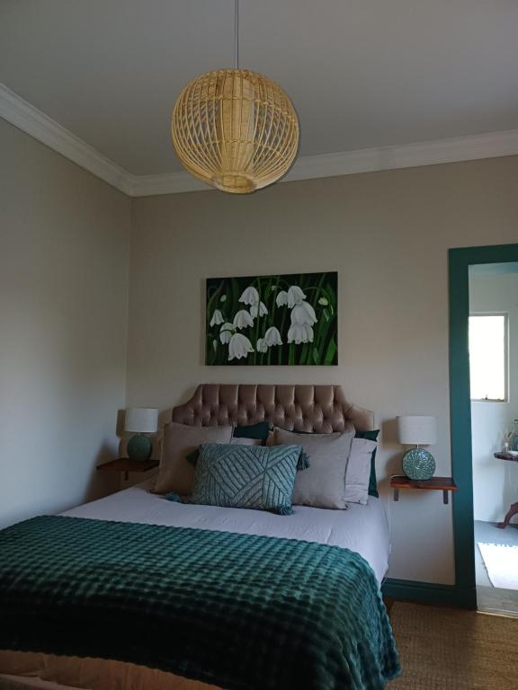 a bedroom with a large bed with a green blanket at 7th Heaven Guest Unit in Paarl