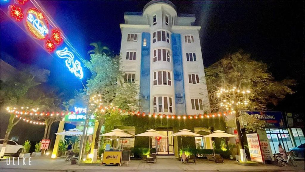 a tall white building with lights in front of it at Nam Phong Hotel & Coffee in Cái Rồng