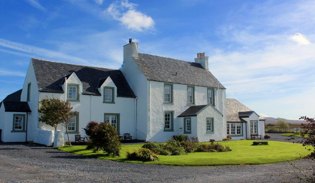 a white house with a black roof at Glenegedale House in Kintra