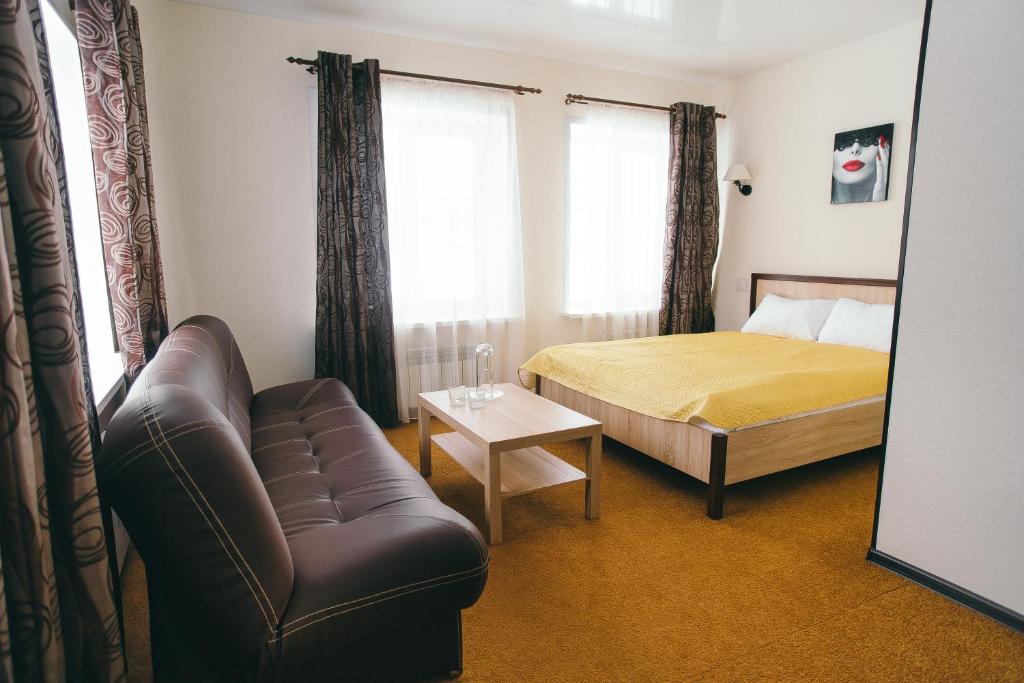 ヨシュカル・オラにあるKristall Hotel & Restaurant Complexのソファ、ベッド、鏡が備わるベッドルーム1室が備わります。