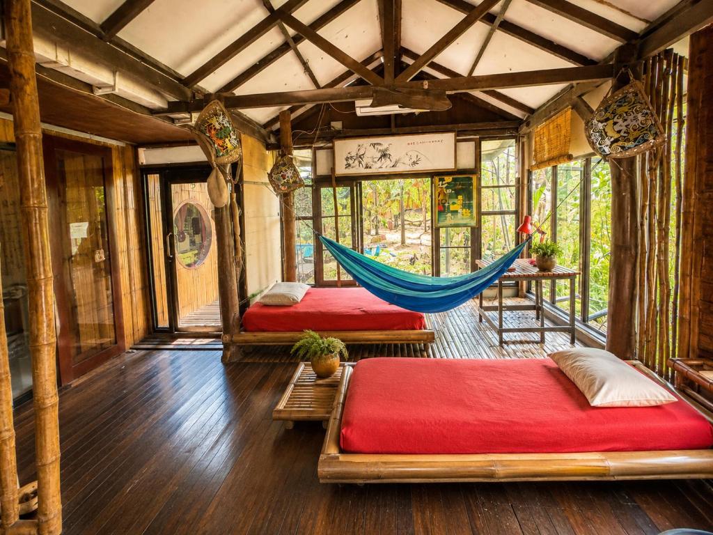 a room with two beds and a hammock in it at The Secret Sanctuary in Kuching