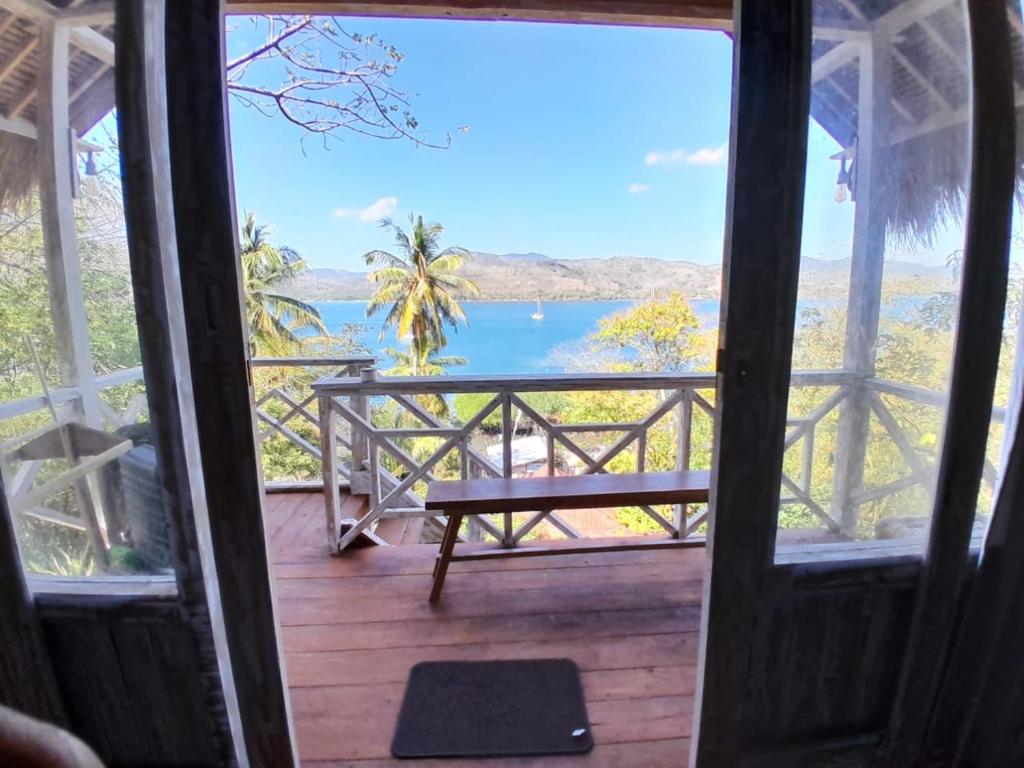 a door to a porch with a view of the water at Lombok eco Lumbung in Gili Gede