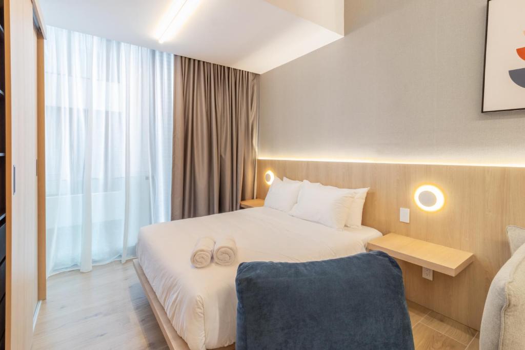 a hotel room with a bed and a chair at Myla Magnolia in Mexico City