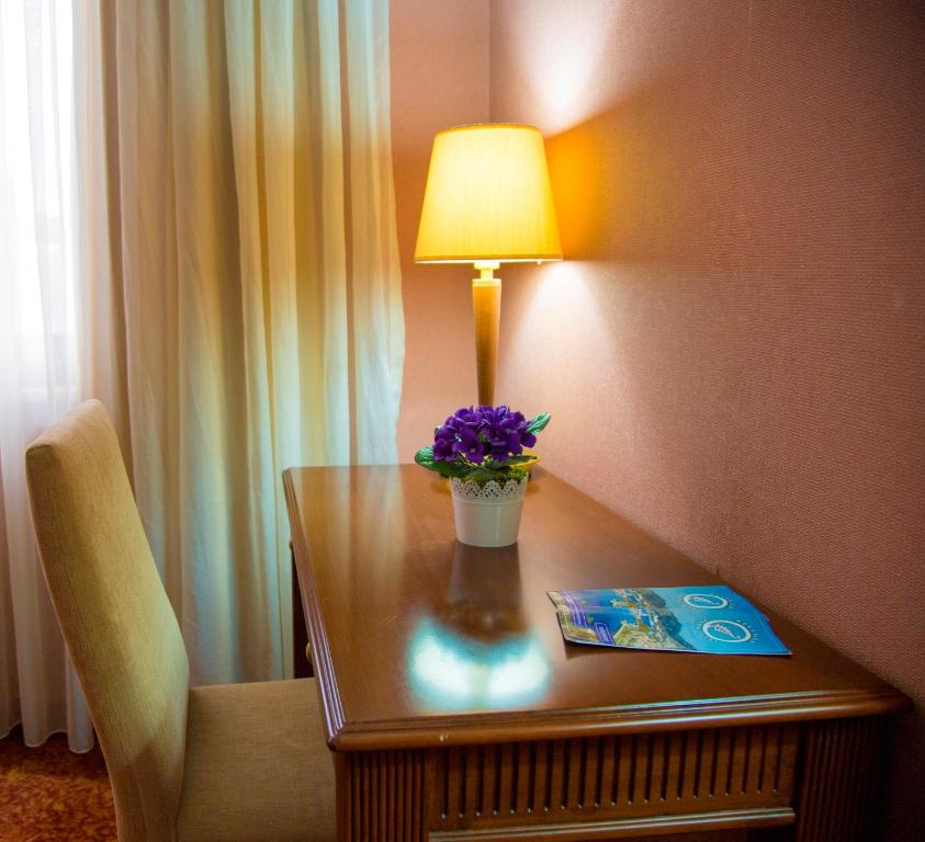 a table with a lamp and purple flowers on it at Kelesler Park Hotel in Ereğli