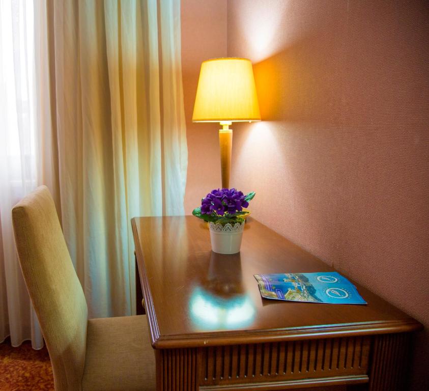 einen Tisch mit einer Lampe und lila Blumen drauf in der Unterkunft Kelesler Park Hotel in Ereğli