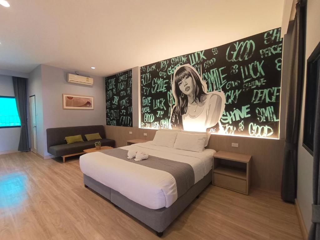 a bedroom with a bed and a wall with writing on it at Tarnsiri Boutique Resort in Kanchanaburi City