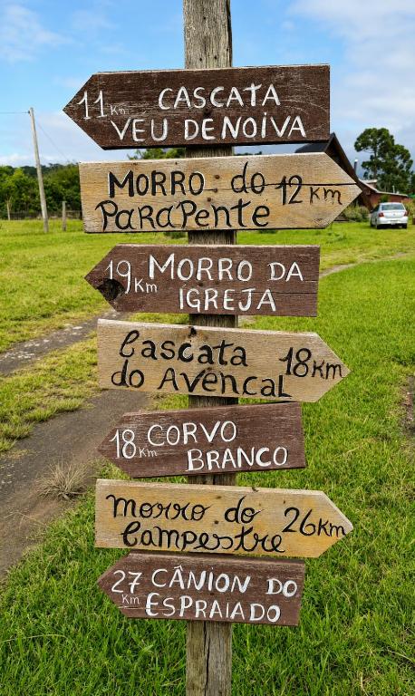 a directional sign on a pole in a field at Pé na Picada in Urubici