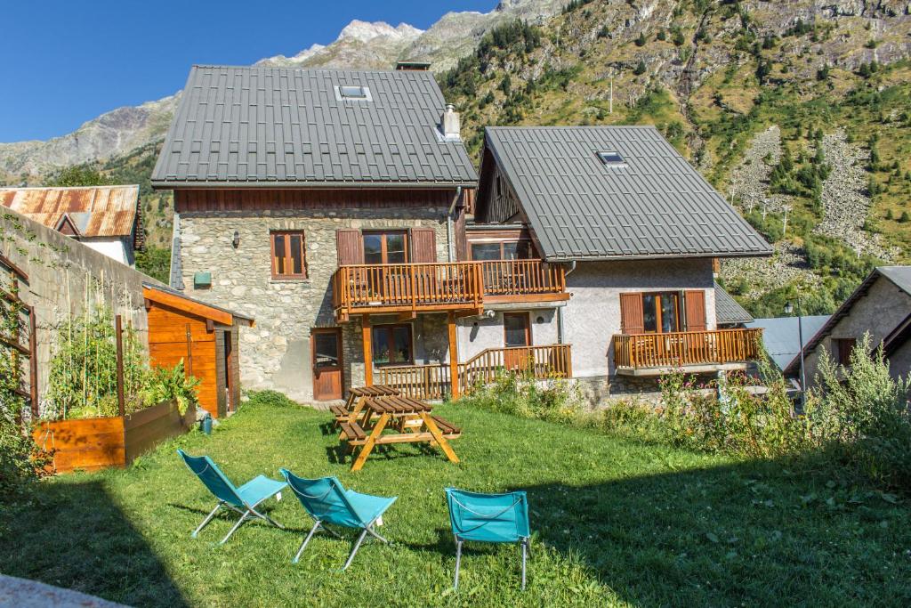 a house with chairs and a table in the yard at Chalet Lucette - bijoux style 200m from the piste in Vaujany
