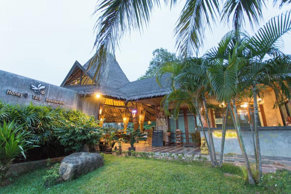 a house with palm trees in front of it at Samui Honey Tara Villa Residence in Choeng Mon Beach