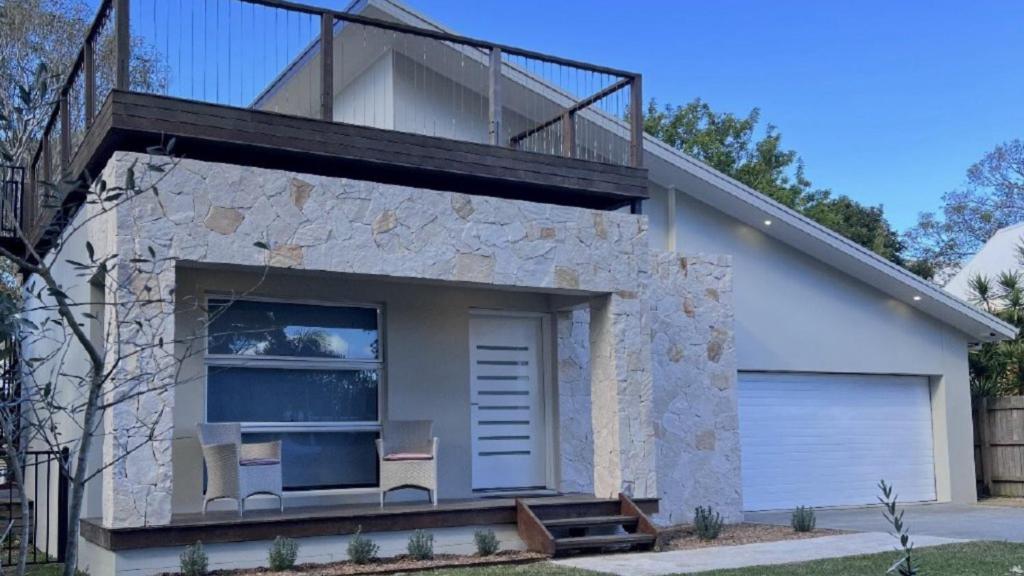 a house with two chairs and a balcony at Pet Friendly With Privacy, Excellence & Wifi in Hawks Nest