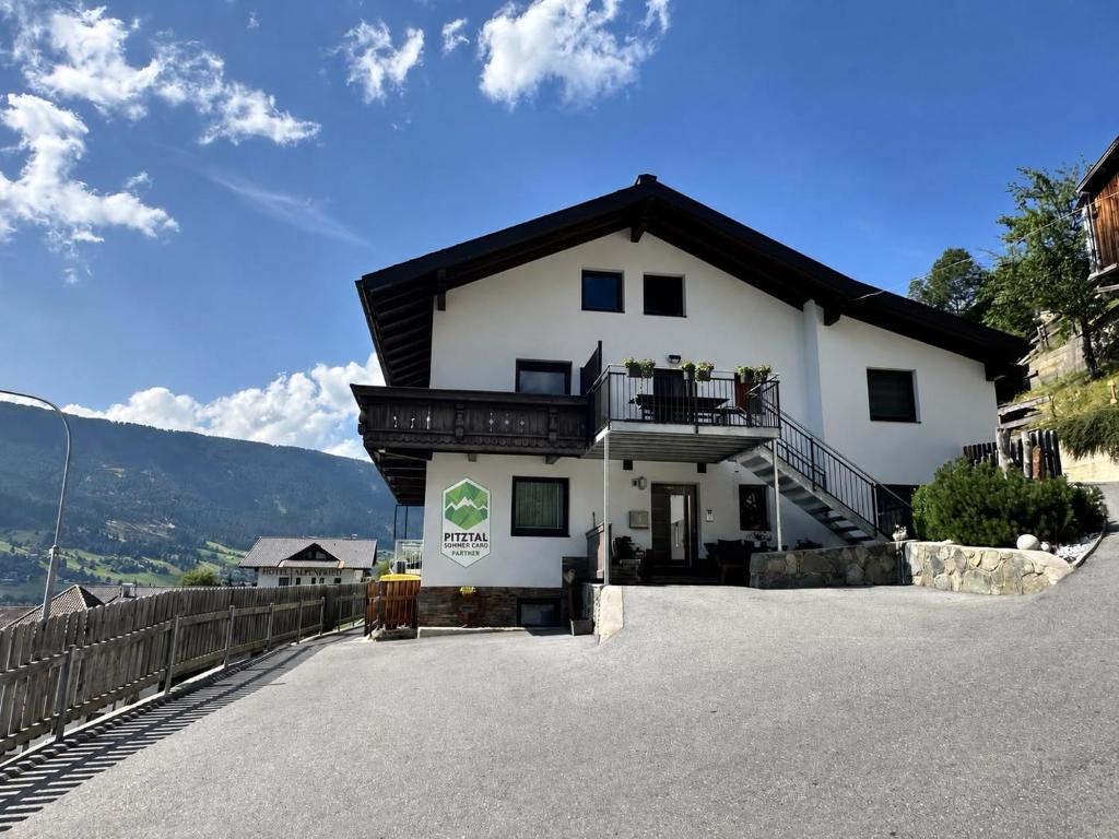 a white house with a black roof at Apart Neunerhof in Jerzens
