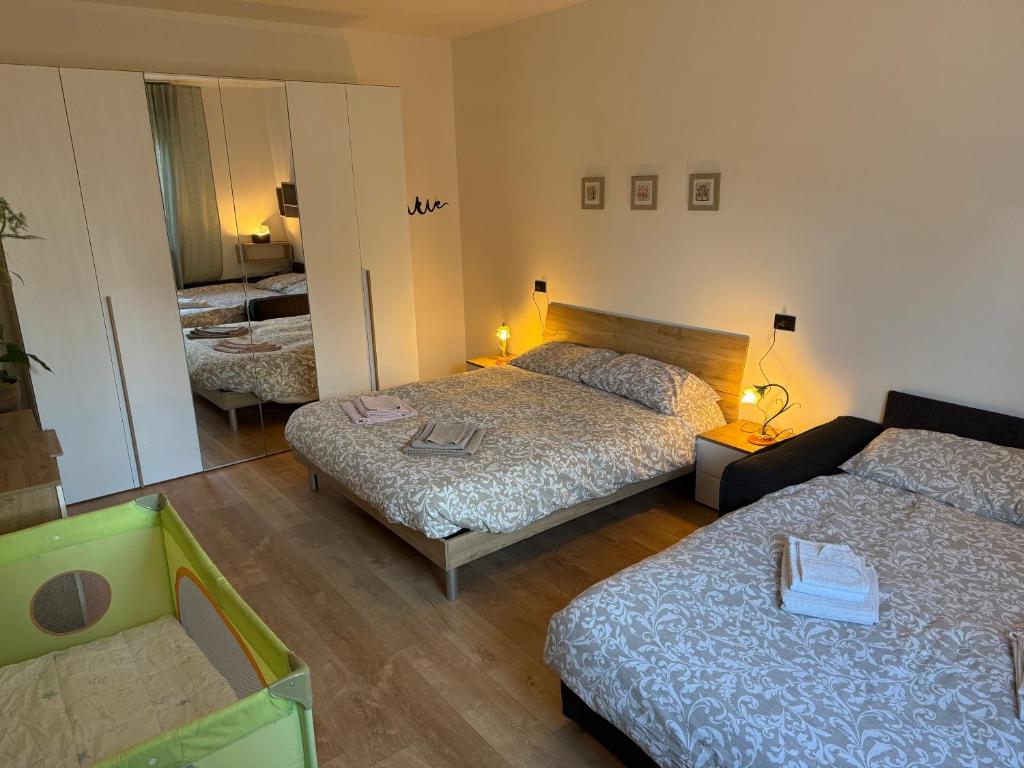 a hotel room with two beds and a mirror at Ai Melograni Apartment in Silea
