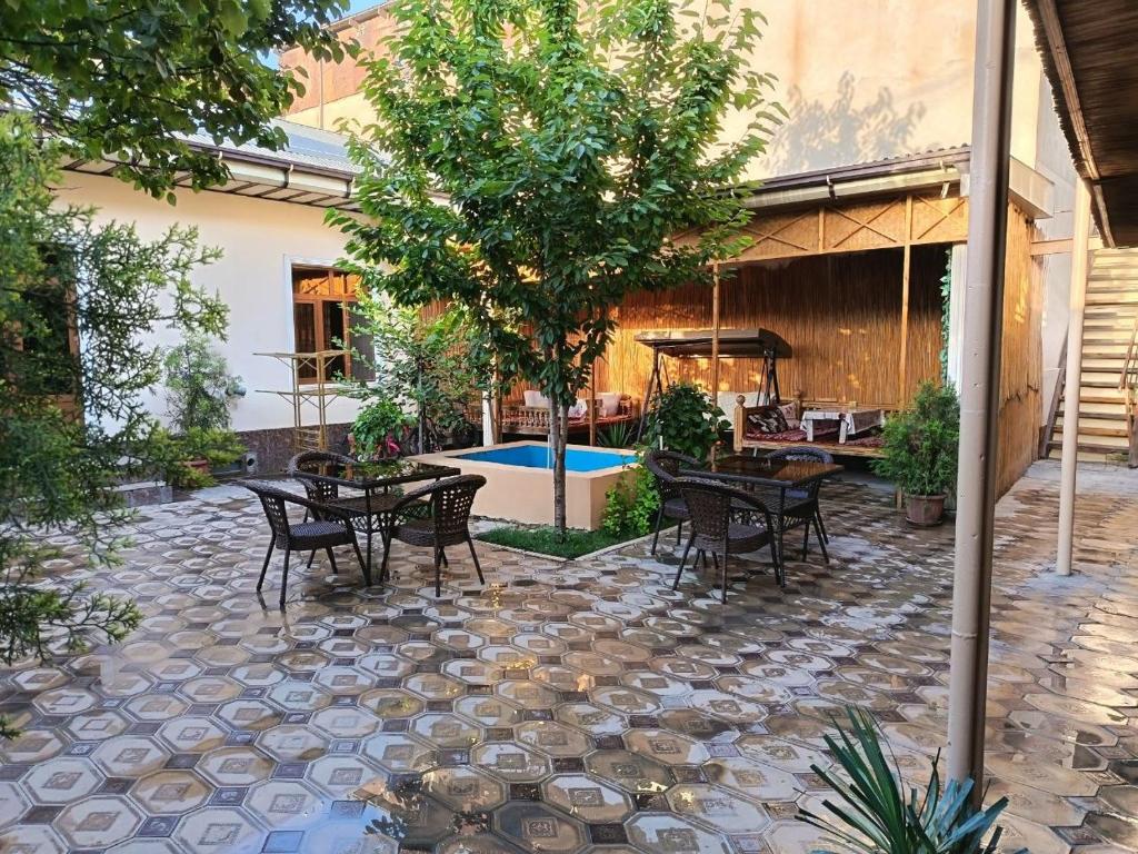 a patio with tables and chairs and a tree at SAMARKAND AMIRA in Samarkand