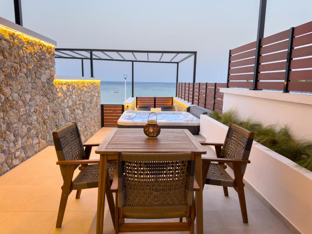 a balcony with a table and chairs and a bed at Marizon Suites - Adults Only in Vrachonisída touArchangélou