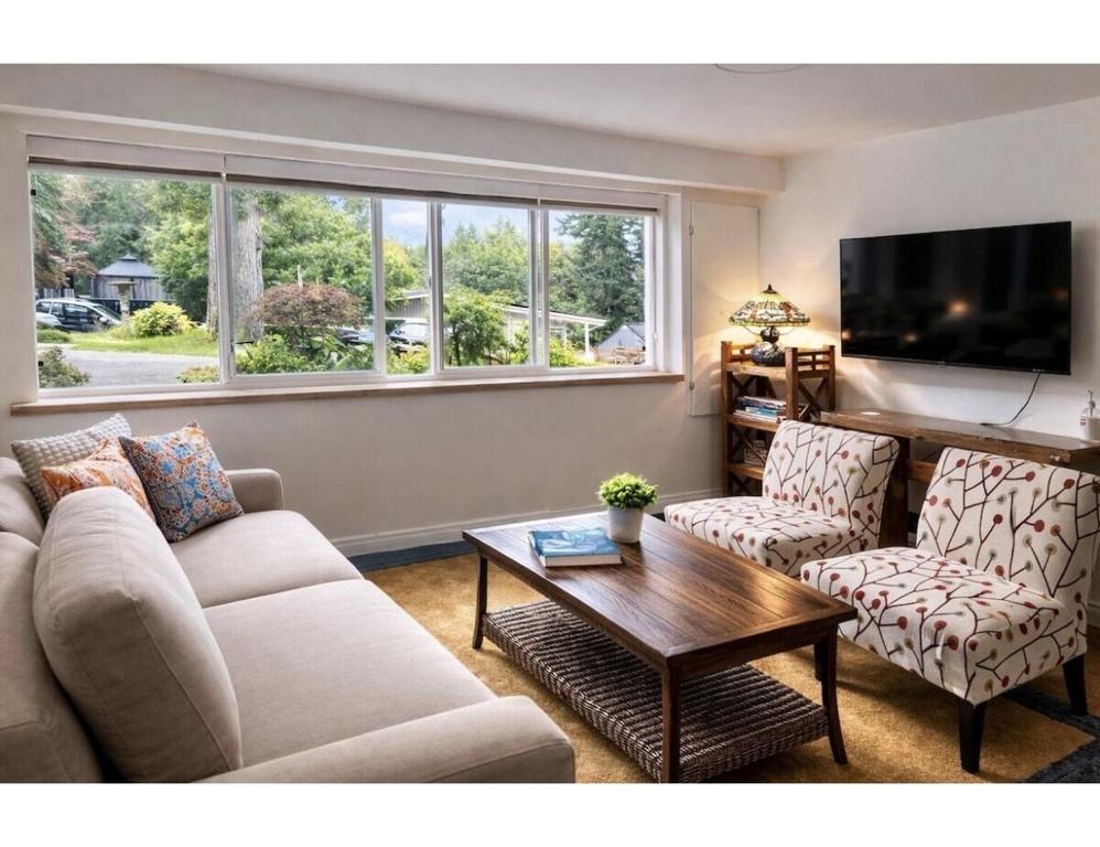 a living room with a couch and two chairs and a table at Cozy Coastal Retreat Close to Beach Park in Port Moody