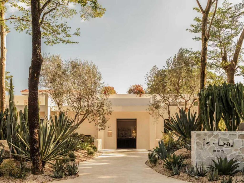 a driveway leading to a building with trees at is.land Villa in Sanya
