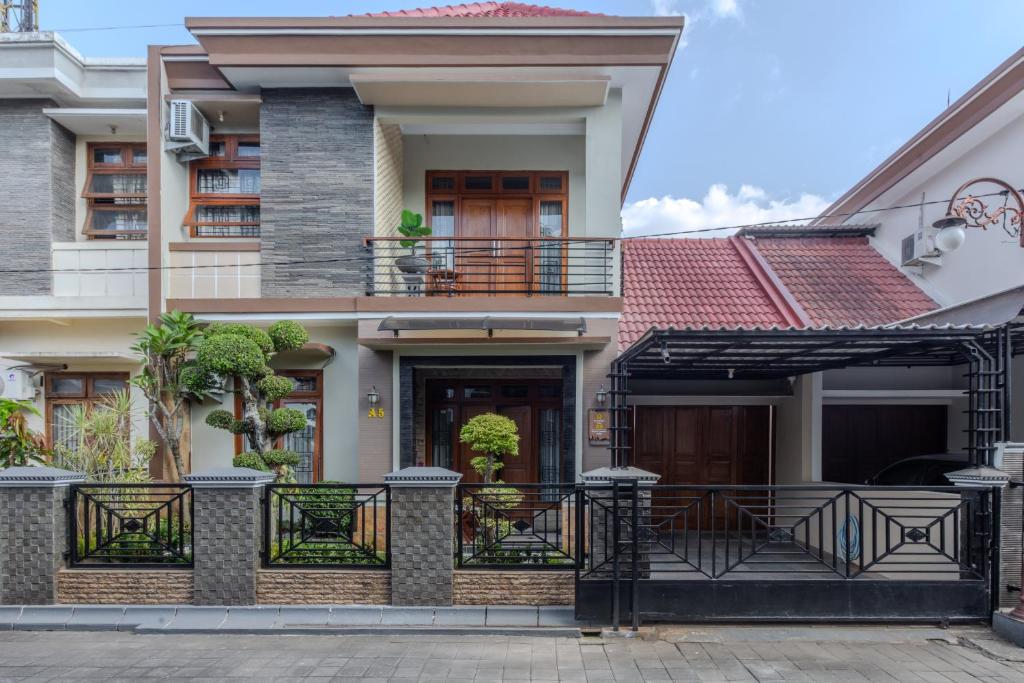 a house with a gate and a balcony at Homestay Rumahnya Diaz in Kejayan