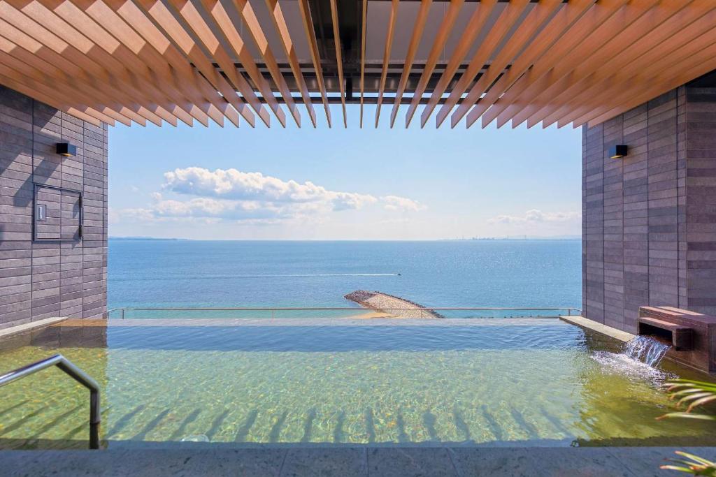 a swimming pool with a view of the ocean at REX HOTEL Beppu in Beppu