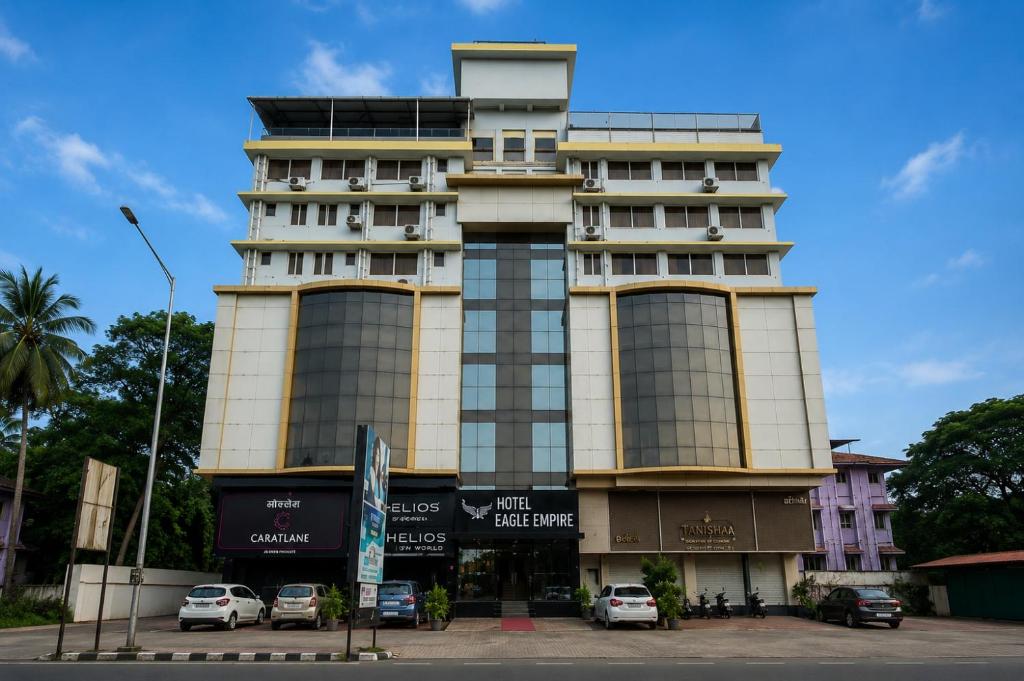 a tall building with cars parked in front of it at Hotel Eagle Empire in Madgaon
