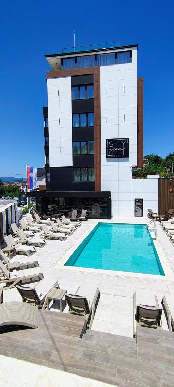 a swimming pool with lounge chairs and a building at Sky Panorama in Soko Banja