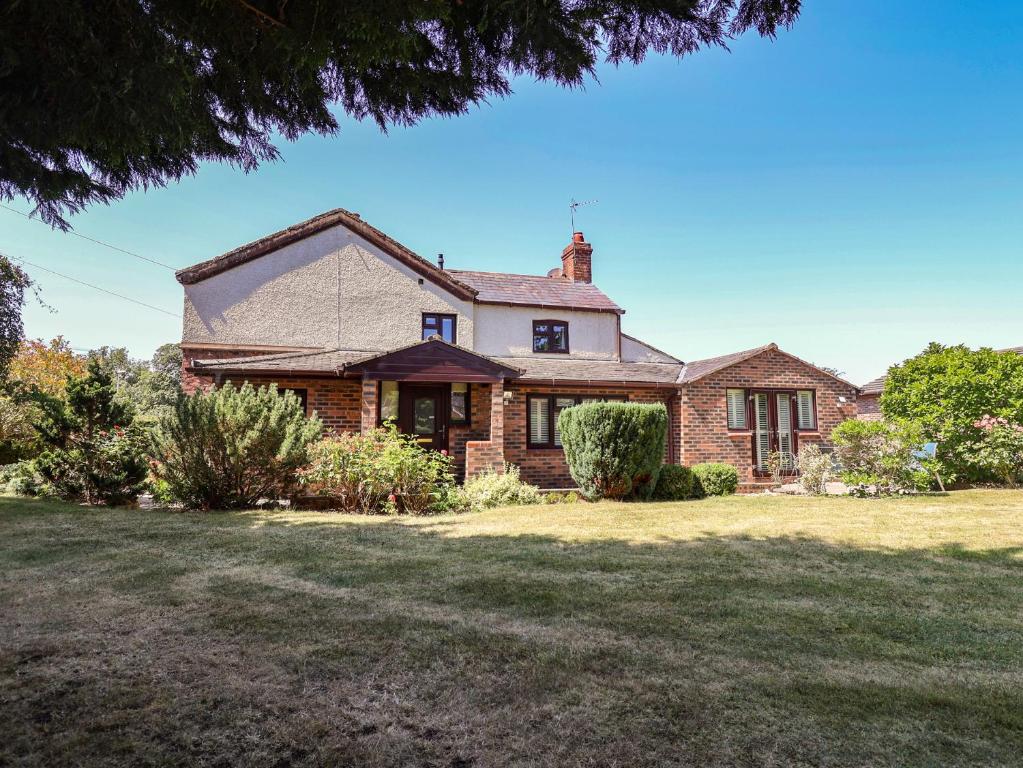 an old brick house with a grass yard at 4 Green Farm Cottage in Chester