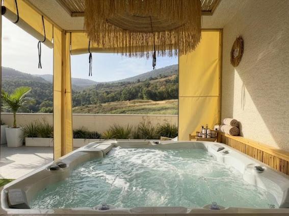 a jacuzzi tub in a building with a view at טל תאי בוטיק - Tal Thai Boutique in Shelomi