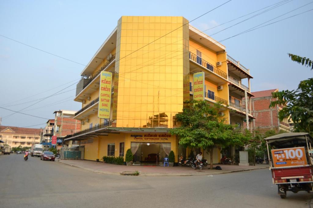 a yellow building on the side of a street at Capital Battambang Hotel in Battambang