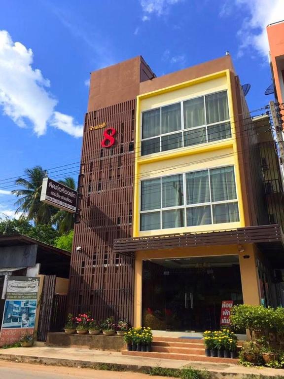 a building with a red sign on the side of it at Ratchanee Place in Chaiyaphum