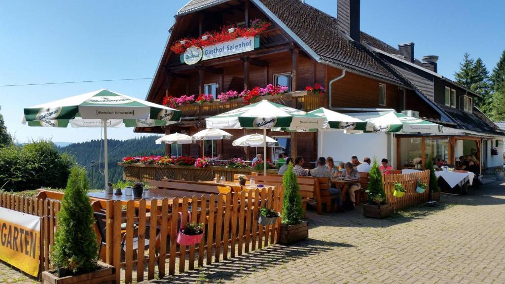 蒂蒂湖－新城的住宿－Schwarzwaldgasthaus Salenhof，大楼前的餐厅,配有桌子和遮阳伞