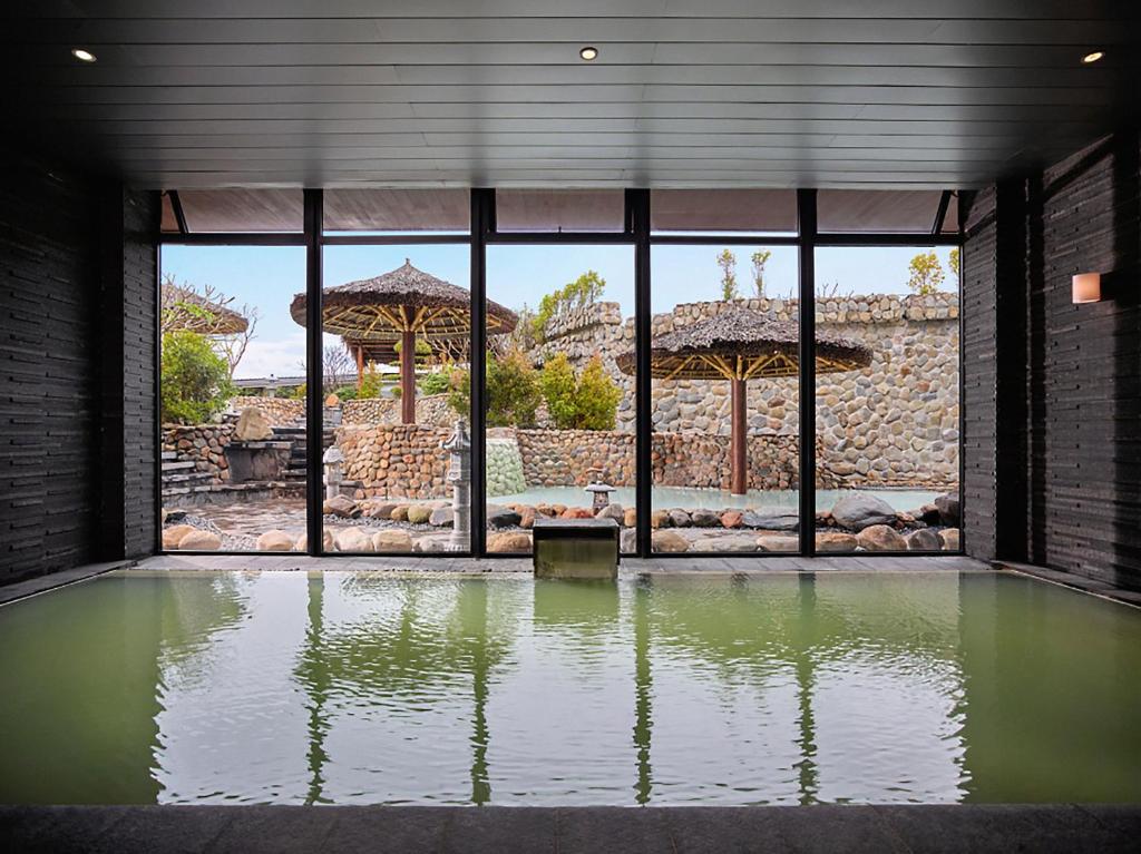 a large pool of water in a room with windows at Kobi Onsen Resort Hue, Affiliated by Meliá in Hue