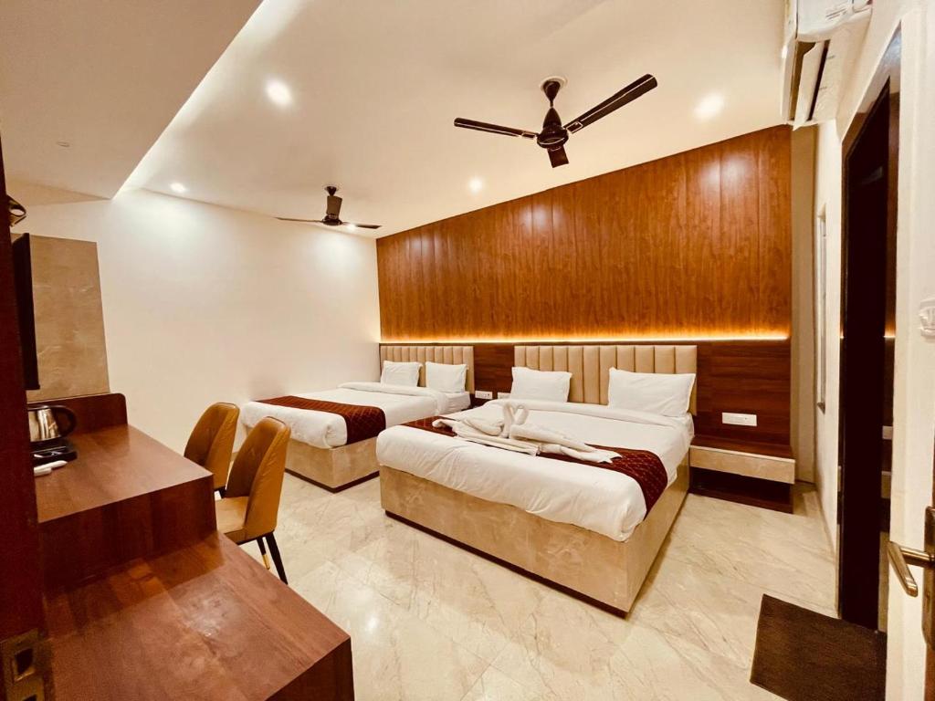 a bedroom with two beds and a ceiling fan at Raghuwar Palace in Ayodhya