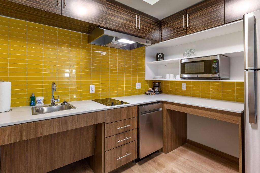 a kitchen with a sink and a microwave at MainStay Suites Carlsbad South in Carlsbad