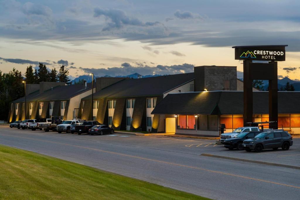 a building with cars parked in a parking lot at Crestwood Hotel in Hinton