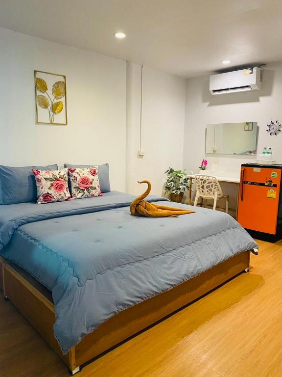 a bedroom with a blue bed with a wooden floor at ลุงชีพบ้านพัก เกาะล้านLoongcheeb House in Ko Larn