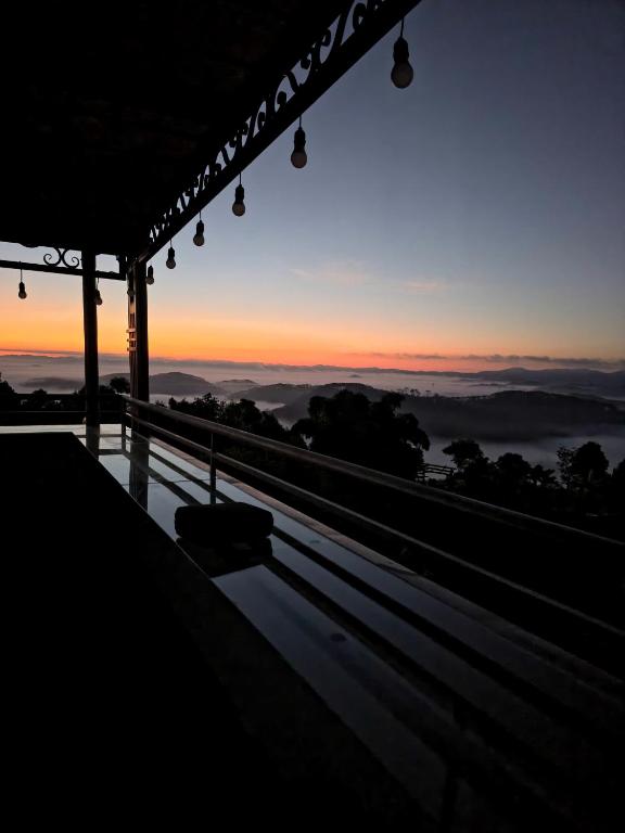 a view of the sunset from a mountain top with lights at Huỳnh Nga Măng Đen Hotel in Kon Plong
