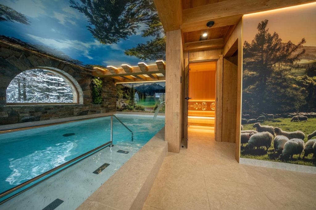 a swimming pool in a house with a painting of sheep at WHY NOT Myśliwska Exclusive Residence z basenem in Kościelisko