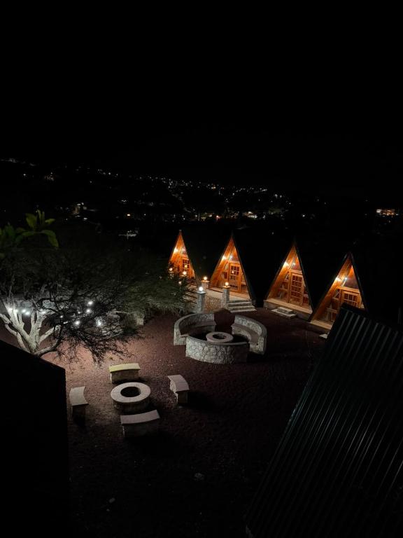a group of lodges at night with lights at azomalli cabañas in Bernal