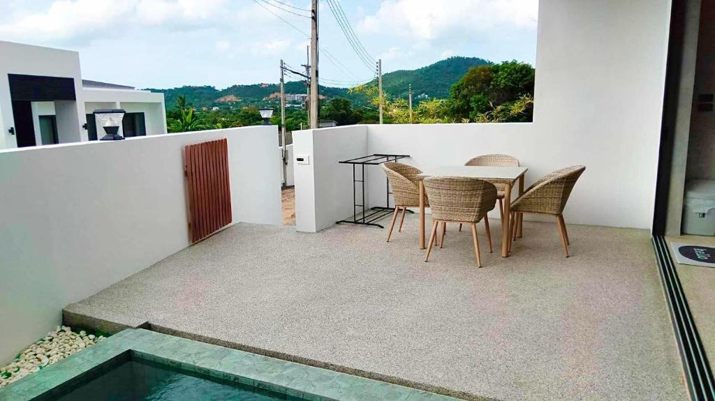 a patio with a table and chairs on a balcony at Big leaf villa cozy in Bangrak Beach