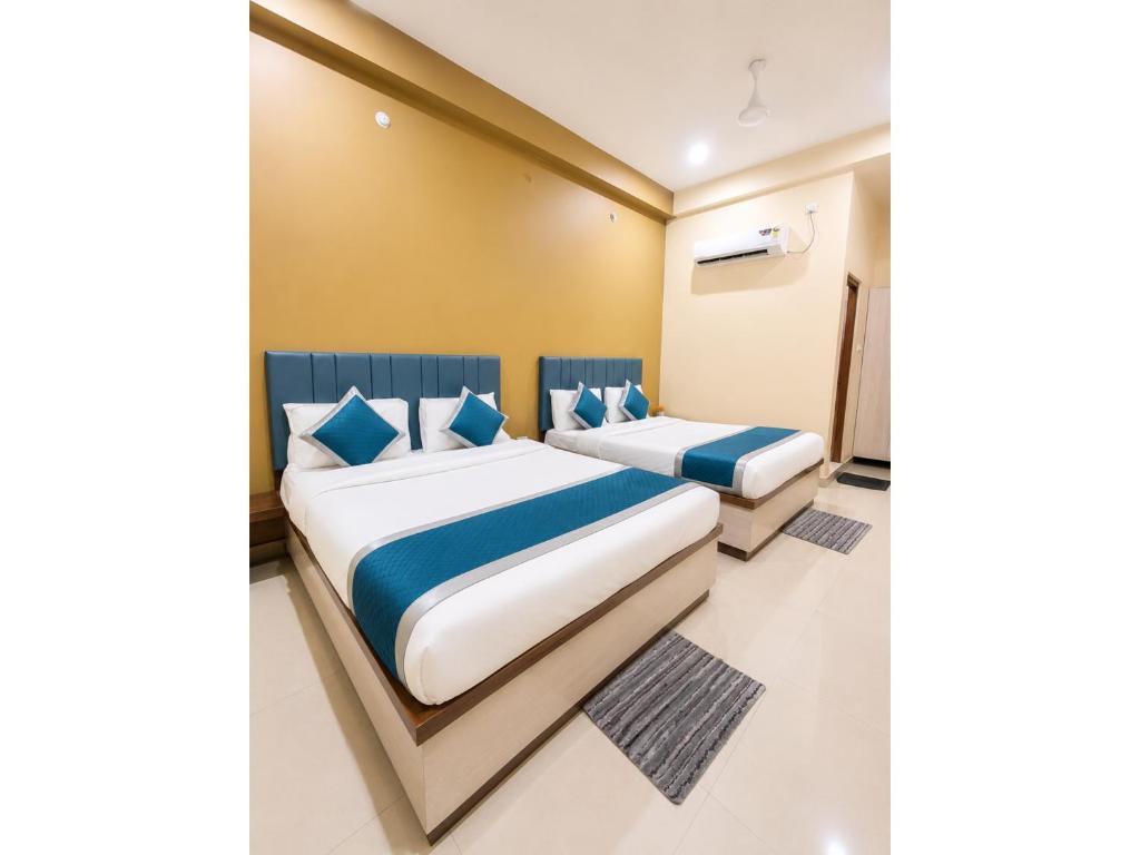 a bedroom with two beds with blue pillows at HOTEL MEDHYA GRAND Near Goḏawalia Chauraha - 200 Meter From Baba Vishwanath Temple & Ganga Arti Ghat ! Wi-Fi #Lift #Hygiene & Spacious Room - BEST HOTEL IN VARANASI in Varanasi