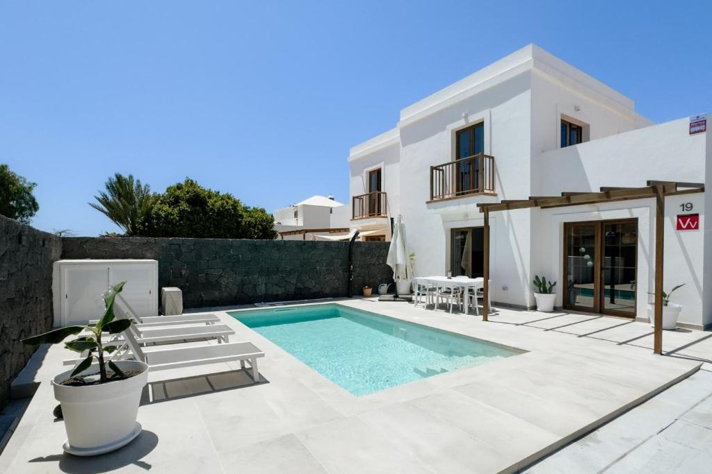 a swimming pool in front of a villa at Villa La Genuina in Yaiza