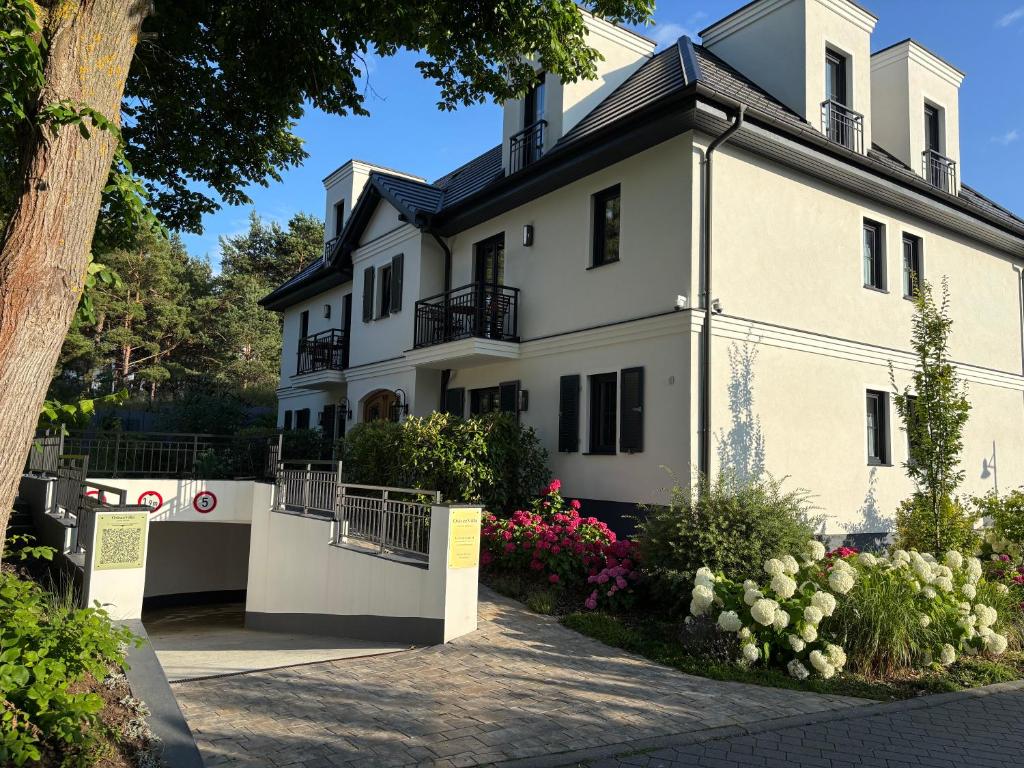a white house with flowers in front of it at OstseeVilla Seebad Ahlbeck Ferienwohnungen in Ahlbeck