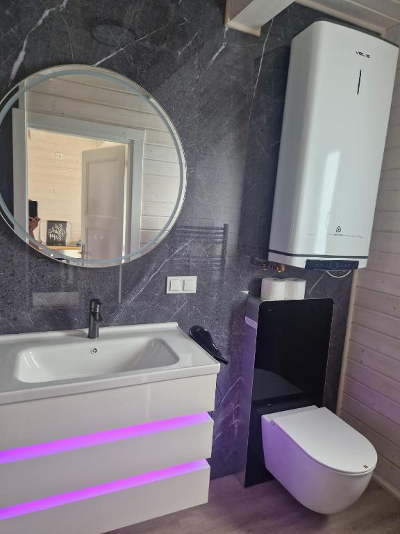 a bathroom with a sink and a toilet and a mirror at San Escobar Dziwnówek in Dziwnówek