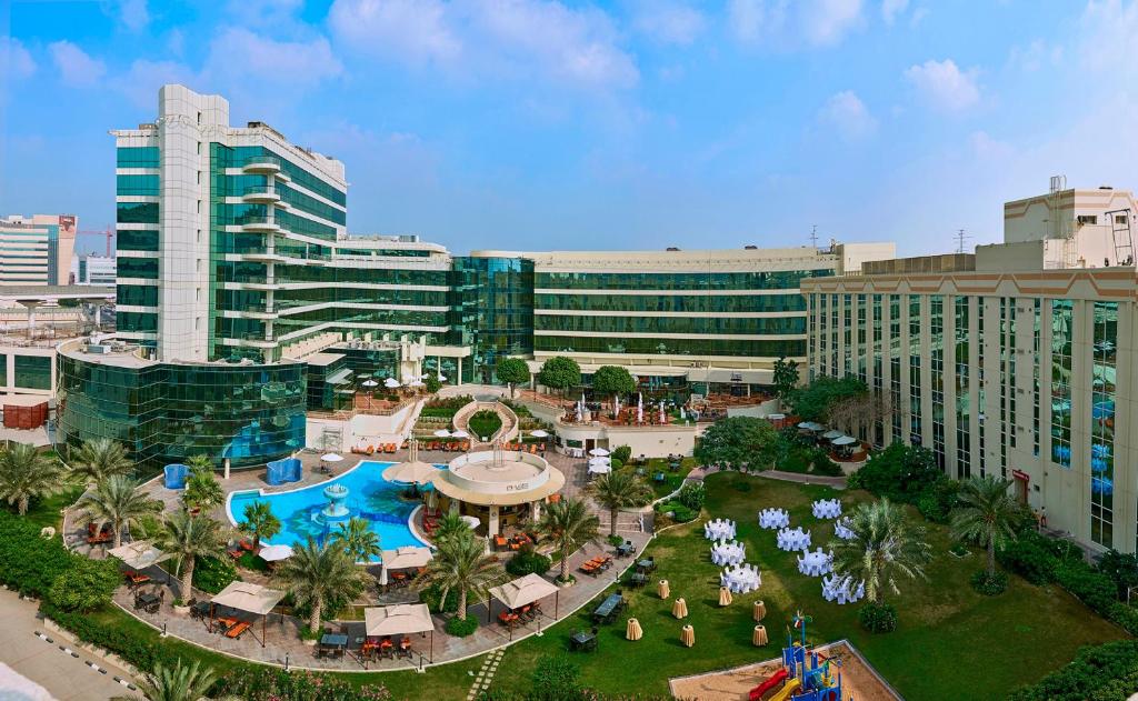 an aerial view of a resort with a swimming pool at Millennium Airport Hotel Dubai in Dubai