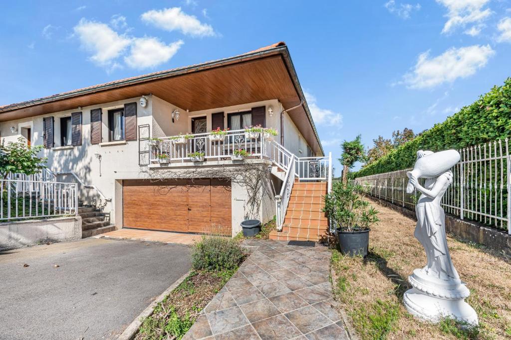 a house with a gate and a statue in front of it at Chez Daniel Et Zdenka in Villars-les-Dombes