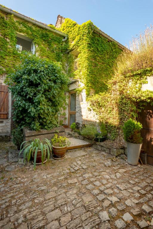 an ivy covered house with a bench and plants at La petite maison CARRÉ in Talant