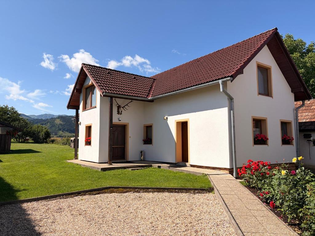 a white house with a grass yard at Penzion Mlynárov Dvor in Dúbrava