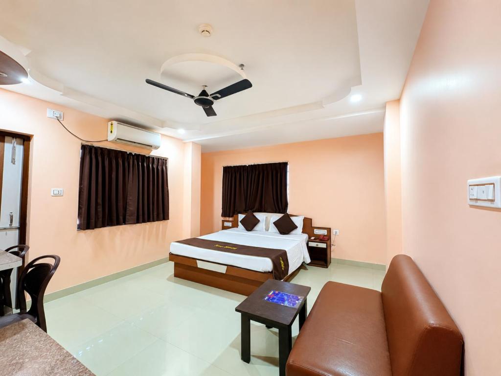 a hotel room with a bed and a couch at Hotel The Four Square in Digha