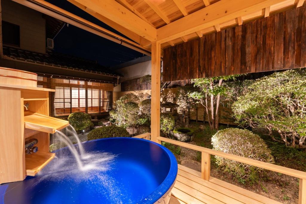 a large blue tub on a deck with a fountain at Villa Taniguchi in Takayama